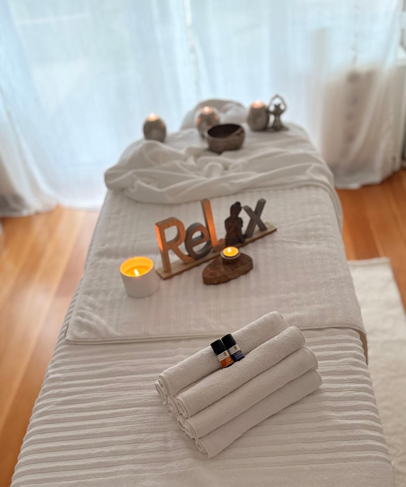 Massage-Liege mit Handtüchern, Klangschale und Entspannungs-Dekoration